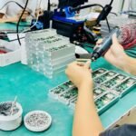 Workers assembling anti - drone modules in electronics factory production line