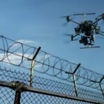 Drone jammer securing prison airspace by intercepting unauthorized UAVs near a barbed - wire fence